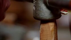 Close-up of a manual metal tool being twisted over wood to create a spindle shape in a workshop. Stock Footage