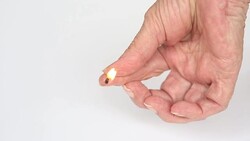 closeup of an older womans hand holding a burning matchstick Stock Footage