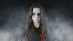 Checking the treats - mysterious teenage girl standing in an eerie, foggy environment Stock Footage