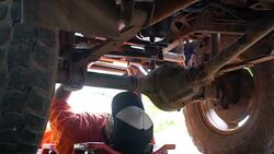 Dolly side of male car mechanic working under vehicle engine Stock Footage