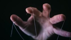 Manipulation concept with puppet string and controlling hand Stock Footage