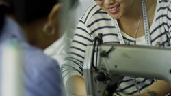 Asian Woman Talking when Sewing Clothes Stock Footage