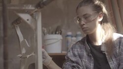 Girl carpenter, designer, decorator, works in a workshop on the restoration of old furniture Stock Footage