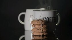 Breton gift biscuits and a cup of coffee on a black background with steam. Stock Footage