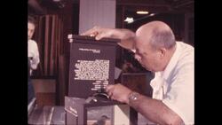 1970s: Man inserts board containing exhibit label into back of box containing stuffed bird Stock Footage