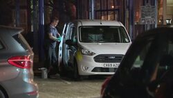 Forensic investigator putting a suit on at a crime scene in Camden News Clip