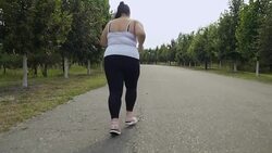 Fat girl runs along the road Stock Footage