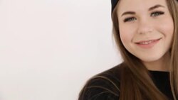 a teenage girl in black hip-hop clothes and a cap dances at the white wall- close-up, handheld shoot, small depth of field Stock Footage