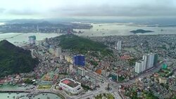 4k Aerial view over city and park with Bai Tho karst mountain Ha long bay. Halong City. Stock Footage