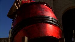 PAN UP OF DRUM AND DRUMMER. MAN OR MUSICIAN. COULD BE TAIKO DRUM. CASTLE IN BG. COULD BE ANCIENT MIDDLE EAST. Stock Footage