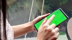 Young woman uses smartphone with green screen Stock Footage