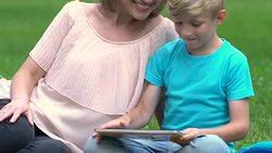 Pregnant mum playing game on tablet with son, happy motherhood, family planning Stock Footage