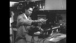 Man works with flasks and cylinders in radiation experiment at UCLA's Atomic Energy Project News Clip
