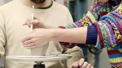 Teacher using tool on clay container by student Stock Footage