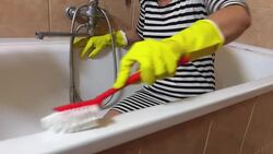 Woman in yellow gloves with red brush clean bath Stock Footage