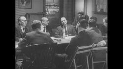 1960s: Group of men sit around table, talk, smoke cigarettes Stock Footage