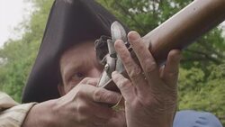 Sunlight on Revolutionary War soldier aiming musket Stock Footage