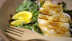 Dolly Shot of Chicken breast with fresh salad - arugula and sliced lemon and onion Stock Footage