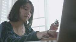 Young woman with credit card and laptop paying bills online in her room. Stock Footage