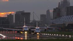Aircraft taxi down London City Airport runway Stock Footage