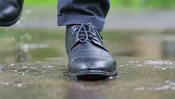 Man in black shoes stepping into the puddle in 4k slow motion 60fps Stock Footage