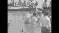Rev. Russell Ridgeway baptizes young women in the Mississippi River News Clip