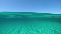 SLOW MOTION: Picturesque view from the turquoise ocean of the distant island. Stock Footage