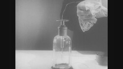 1950s: Hand touches wire to bell jar lid Stock Footage