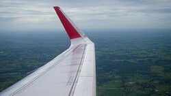 Airplane flight. Wing of an airplane flying above the clouds from window plane view Stock Footage