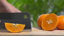 4k cutting of slice orange on wooden cutting board. Stock Footage