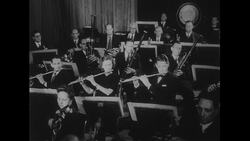 Australia, c.1951: An orchestra plays a tune during a concert Stock Footage