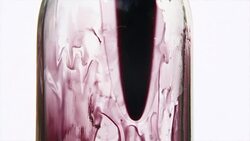 Dark thick liquid flowing down glass Stock Footage