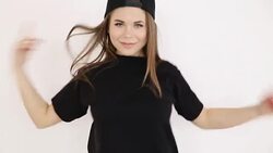 a teenage girl in black hip-hop clothes and a cap dances at the white wall- close-up, handheld shoot, small depth of field Stock Footage