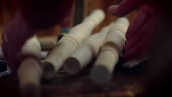 Four shaped chair legs lying on tools on a workshop bench are picked up. Stock Footage