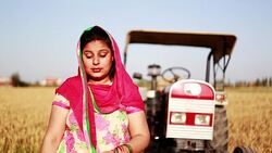 Indian women standing portrait near field & tractor Stock Footage