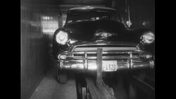 United States, c.1951: A car is loaded into an elevator in a parking garage through the control of an attendant Stock Footage