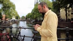 Portrait of A lost young man with smartphone looking for direction in the city Stock Footage