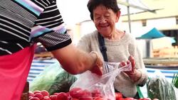 Senior Japanese Woman Customer and Salesman at Farmers Market Stock Footage
