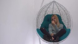 Beautiful girl thumbs a magazine in the chair Stock Footage