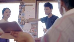 Creative designers discussing photographs in office Stock Footage