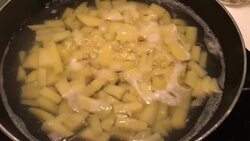 A chef in a professional kitchen cooking mashed potatoes in metal pan on rustic table background in the kitchen. Concept diet, food, Italian and nutrition. Stock Footage