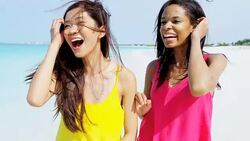 Laughing African American Asian Chinese girls on beach Stock Footage