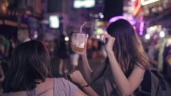 Slow motion - Traveler backpacker Asian women lesbian lgbt couple dancing together. Female drinking alcohol or beer with friends and having party at The Khao San Road in Bangkok, Thailand. Stock Footage