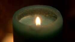 CLOSE ANGLE OF GREEN CANDLE AND FLAME. Stock Footage