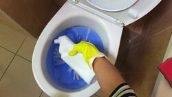 Housewife is pouring blue cleaning fluid into the toilet bowl Stock Footage
