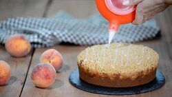 Cook decorating a cake with icing sugar with a piping bag. Summer peach pie with caramel sugar crumb. Stock Footage