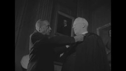Man assists newly appointed Supreme Court Justice Earl Warren with judge's robes News Clip