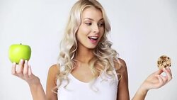 happy young woman with green apple and cookie Stock Footage