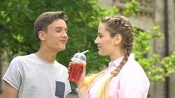 Happy teenage couple having fun together, chewing gum, drinking soda, slow-mo Stock Footage