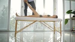 Male physiotherapist giving leg massage to female patient Stock Footage